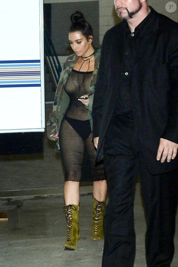 Kim Kardashian à Los Angeles, porte une veste camo de la ligne de merch PABLO, une robe noire et des bottines lacées en daim. Le 14 juillet 2016.