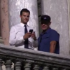 Jamie Dornan et un assistant au balcon de l'Opéra Garnier à Paris le 18 juillet 2016. L'acteur britannique a pris des photos des fans en bas.