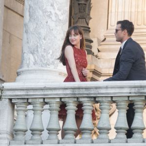 Dakota Johnson (robe Elie Saab) et Jamie Dornan tournent une scène du film "50 nuances plus sombres" sur le balcon de l'Opéra Garnier à Paris le 18 juillet 2016.