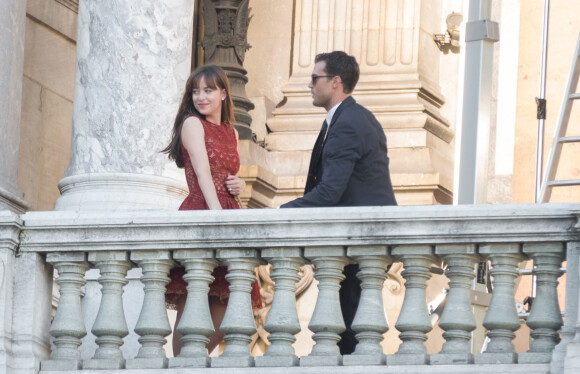 Dakota Johnson (robe Elie Saab) et Jamie Dornan tournent une scène du film "50 nuances plus sombres" sur le balcon de l'Opéra Garnier à Paris le 18 juillet 2016.