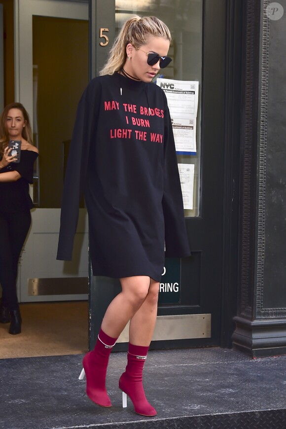 Rita Ora quitte son appartement dans le quartier de Tribeca à New York, habillée d'un pull (porté en robe, collection automne 2016) et de chaussures (collection printemps 2016) Vetements. Le 19 juillet 2016.
