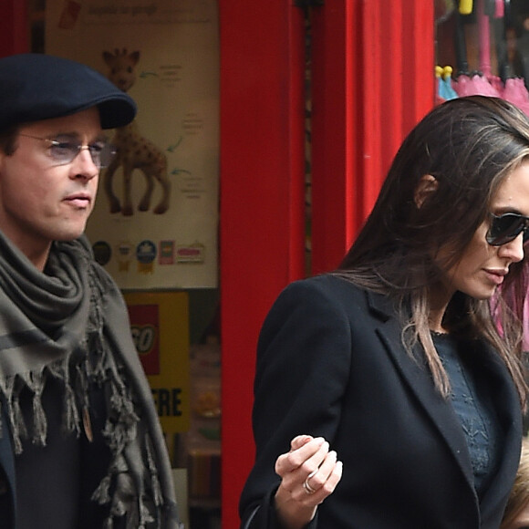 Brad Pitt, sa femme Angelina Jolie et leurs filles Vivienne et Zahara quittent un magasin de jouets à Londres le 12 mars 2016.