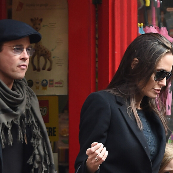 Brad Pitt, sa femme Angelina Jolie et leurs filles Vivienne et Zahara quittent un magasin de jouets à Londres le 12 mars 2016.