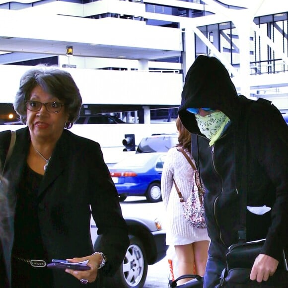 Exclusif - Val Kilmer, visage caché par un bandana et capuche sur la tête, arrive à l'aéroport LAX de Los Angeles. Le 11 août 2015 © CPA / Bestimage
