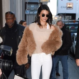 Kendall Jenner quitte le magasin Gucci à Paris, habillée d'une veste camel en (fausse ?) fourrure, d'un pull beige Nili Lotan (modèle Gabrielle), d'un jean Mother et de chaussures Versace. Des lunettes de soleil Linda Farrow accessoirisent sa tenue. Le 28 novembre 2016.