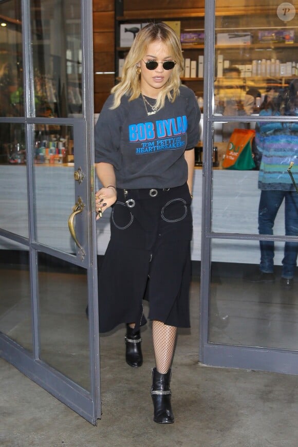 Rita Ora quitte le salon de beauté Méche à Beverly Hills, habillée d'un pull à l'effigie de Bob Dylan et du groupe "Tom Petty and the Heartbreakers", d'une jupe noire et de chaussures Saint Laurent. Le 1er décembre 2016.