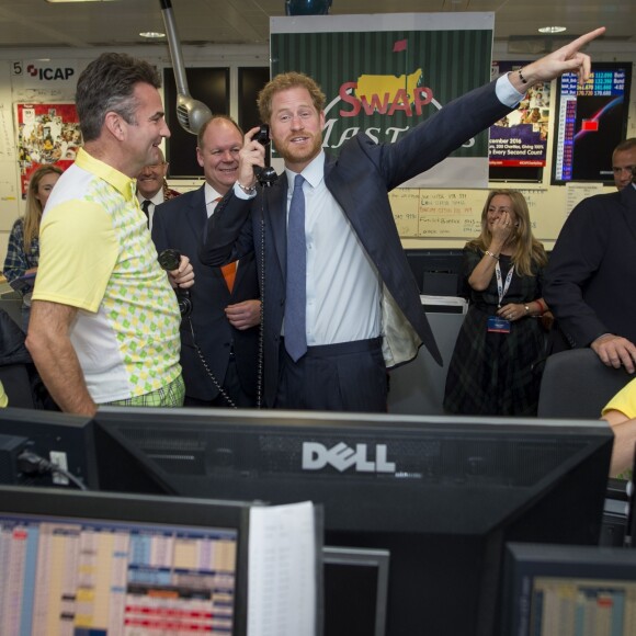 Le prince Harry participe avec d'autres personnalités du monde du sport, de la télévision à la 24ème journée de collecte de fonds caritative dans une salle de l'ICAP à la City à Londres, le 7 décembre 2016.