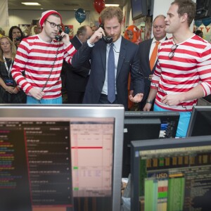 Le prince Harry participe avec d'autres personnalités du monde du sport, de la télévision à la 24ème journée de collecte de fonds caritative dans une salle de l'ICAP à la City à Londres, le 7 décembre 2016.