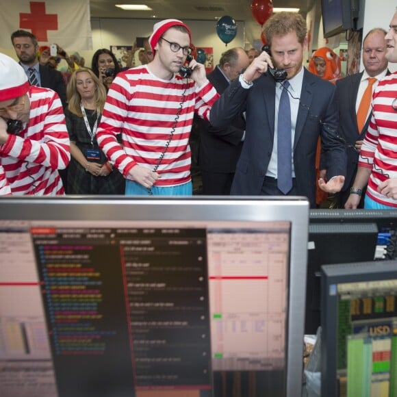 Le prince Harry participe avec d'autres personnalités du monde du sport, de la télévision à la 24ème journée de collecte de fonds caritative dans une salle de l'ICAP à la City à Londres, le 7 décembre 2016.