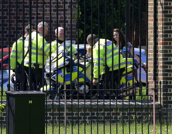 Le prince George de Cambridge monte sur une moto de la police de Londres, le 24 mai 2016, sous les yeux de sa mère la duchesse Catherine.