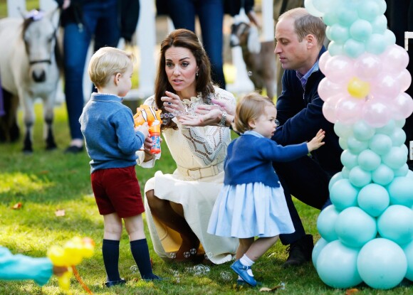 Le prince George de Cambridge se fait gronder après s'être servi de son pistolet à bulles pou tirer sur sa famille, le 28 septembre 2016 lors d'une fête pour enfants à la Maison du Gouvernement à Victoria, au Canada.