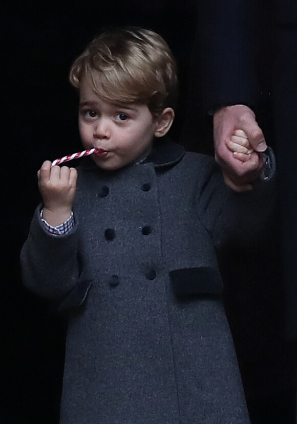 Le prince George de Cambridge savoure une canne en sucre en sortant de l'église d'Englefield après la messe de Noël, le 25 décembre 2016.