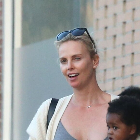 Exclusif - Charlize Theron est allée déjeuner avec ses enfants Jackson et August et s'échappe dans la rue quelques instants pour discuter et plaisanter en FaceTime avec un mystérieux inconnu à Hollywood. Elle s’amuse à faire un doigt d’honneur et envoi un baiser à son interlocuteur avant de raccrocher. Le petit Jackson porte toujours sa casquette fétiche 'reine des neiges' et est habillé en fille. Le 5 juillet 2016