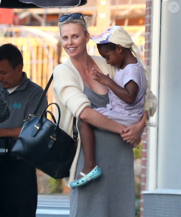 Exclusif - Charlize Theron est allée déjeuner avec ses enfants Jackson et August et s'échappe dans la rue quelques instants pour discuter et plaisanter en FaceTime avec un mystérieux inconnu à Hollywood. Elle s’amuse à faire un doigt d’honneur et envoi un baiser à son interlocuteur avant de raccrocher. Le petit Jackson porte toujours sa casquette fétiche 'reine des neiges' et est habillé en fille. Le 5 juillet 2016