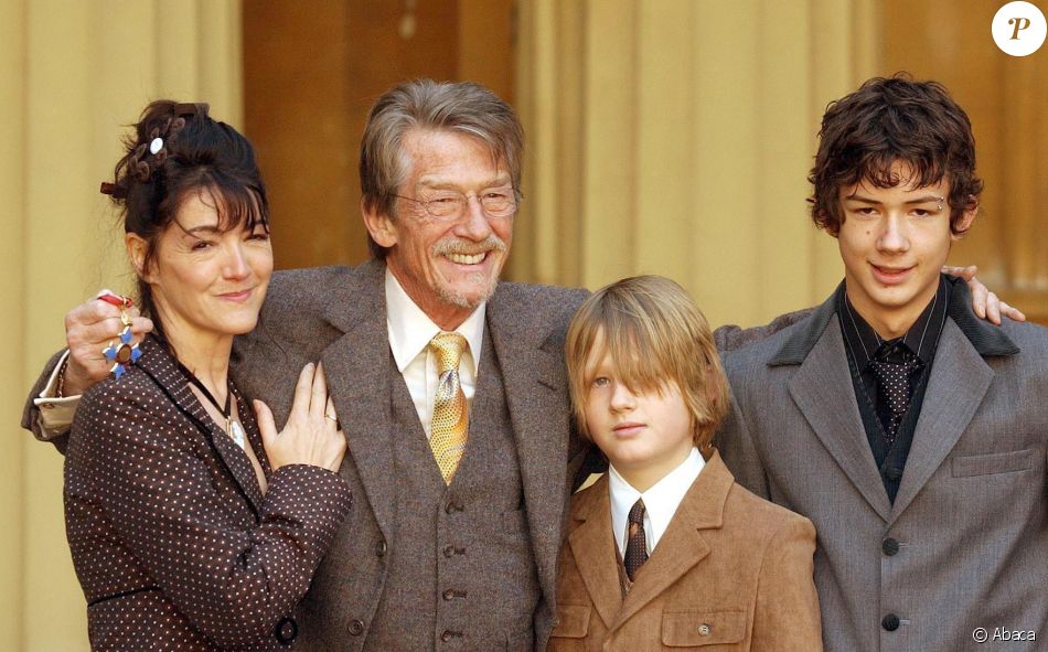  John Hurt en famille lors de la remise de ses insignes de commandeur dans l&#039;ordre de l&#039;empire britannique le 9 décembre 2004, avec sa compagne Anwen et ses fils Alexander (14 ans) et Nicholas (11 ans), issus de son troisième mariage. 