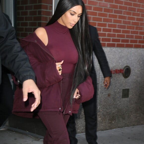 Kim Kardashian habillée de la tête aux pieds en bordeaux avec un haut très transparent à la sortie d'un immeuble à New York, le 15 février 2017.