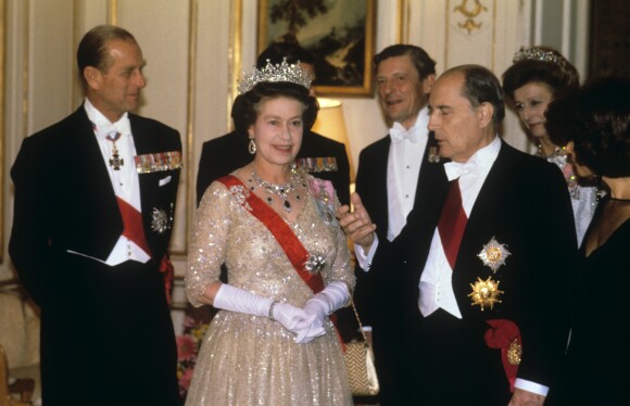 La reine Elizabeth II et François Mitterrand lors d'un dîner d'Etat à l'ambassade de France à Londres en novembre 1984. En arrière-plan, le duc d'Edimbourg, Sir Angus Ogilvy et la princesse Alexandra.
