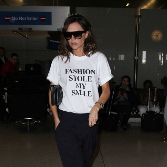 Victoria Beckham porte un t-shirt de sa collection Victoria by Victoria Beckham avec le slogan 'Fashion Stole My Smile' à son arrivée à l'aéroport de LAX à Los Angeles, le 28 mars 2017 © CPA/Bestimage