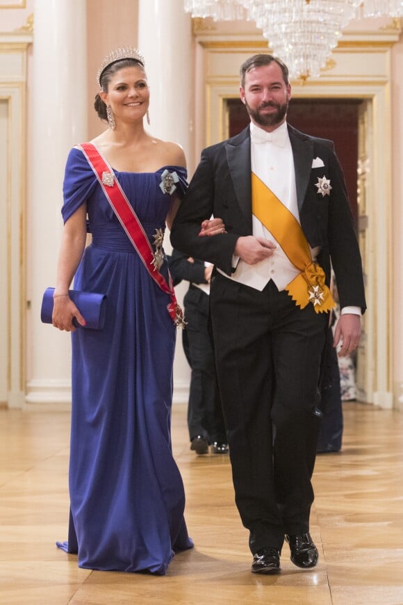 La princesse Victoria de Suède au bras du grand-duc héritier Guillaume de Luxembourg arrivant pour le dîner du double 80e anniversaire du roi Harald V de Norvège et de la reine Sonja de Norvège le 9 mai 2017 au palais royal à Oslo.