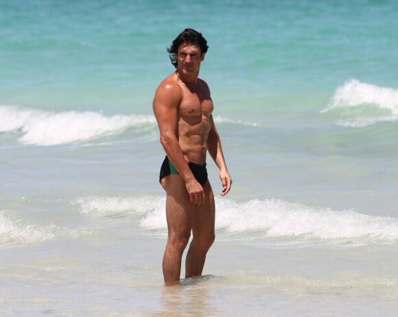 Gregory Basso, mieux connu sous le nom de Greg le Millionnaire, est à la plage à Miami avec une amie, entouré de cameramen le 1er aout 2011.