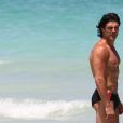 Gregory Basso, mieux connu sous le nom de Greg le Millionnaire, est à la plage à Miami avec une amie, entourés de cameramen le 1er aout 2011.