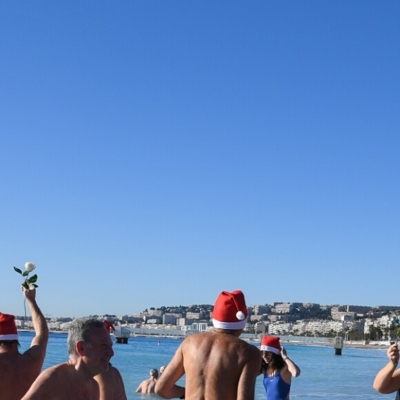 Environ 200 personnes se sont jetées à la mer à l'occasion du 73ème Bain de Noël sur la plage du Ruhl à Nice en présence du maire Christian Estrosi. 86 roses blanches ont été jetées a l'eau pour rendre hommage aux victimes de l'attentat du 14 Juillet 2016. Nice le 17 décembre 2017. © Lionel Urman/Bestimage 