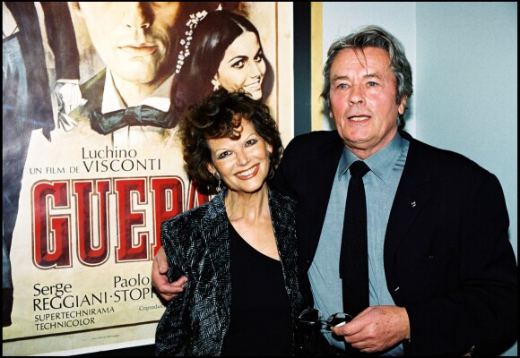 Alain Delon et Claudia Cardinale rendant hommage à Luchino Visconti devant l'affiche du film Le Guépard en 2000
