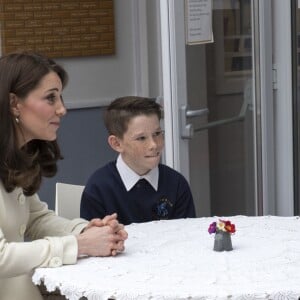 La duchesse Catherine de Cambridge, enceinte de huit mois et vêtue d'un manteau Jojo Maman Bébé, en pleine table ronde avec de jeunes élèves le 6 mars 2018 lors de sa visite à l'école primaire Pegasus à Oxford pour y observer le travail de l'association Family Links UK.