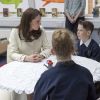 La duchesse Catherine de Cambridge, enceinte de huit mois et vêtue d'un manteau Jojo Maman Bébé, en pleine table ronde avec de jeunes élèves le 6 mars 2018 lors de sa visite à l'école primaire Pegasus à Oxford pour y observer le travail de l'association Family Links UK.