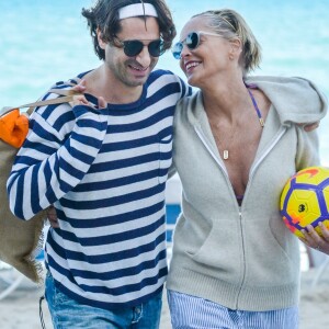 Sharon Stone profite de sa journée avec son nouveau compagnon sur une plage de Miami à la veille des ses 60 ans q'elle fêtera le 10 mars; Miami le 9 mars 2018.  Sharon Stone looked far from single on Thursday as she packed on the PDA with a younger man in Miami and even showed off a diamond ring on her wedding finger. The 59-year-old actress who celebrates her birthday on Saturday, looked incredible in a tiny bikini and striped pants. Miami March 9, 2018.09/03/2018 - Miami