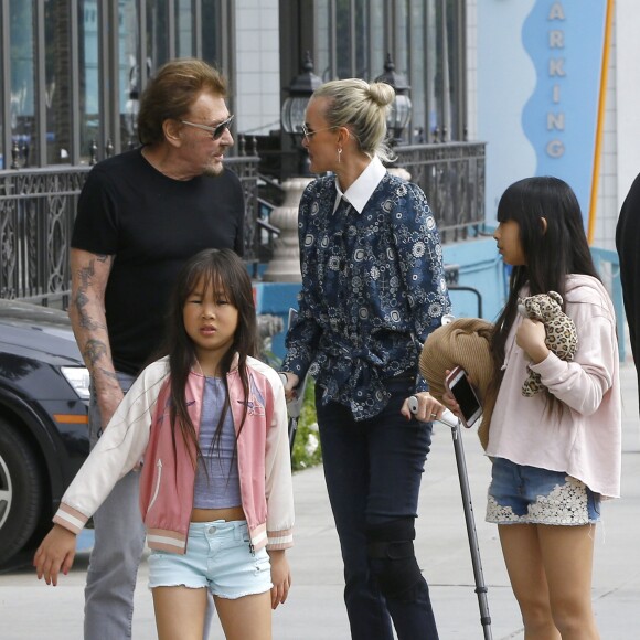 Joy et Jade - Johnny Hallyday, souriant, très en forme et très amoureux de sa femme Laeticia (béquilles) sort déjeuner en famille au Water Grill de Santa Monica le 18 mars 2017 pour l'anniversaire de Laeticia qui fête le jour même ses 42 ans.