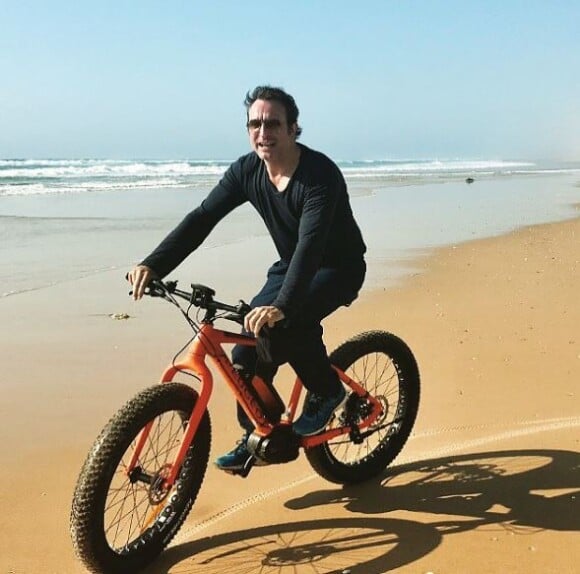 Jean Dujardin fait du vélo sur une plage du Cap-Ferret le 6 mai 2018.