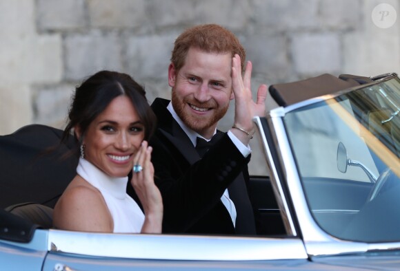 Le prince Harry, duc de Sussex, et Meghan Markle, duchesse de Sussex, quittent le château de Windsor à bord d'une Jaguar Type E cabriolet en tenue de soirée après leur cérémonie de mariage, pour se rendre à la réception à "Frogmore House" à Windsor le 19 mai 2018.