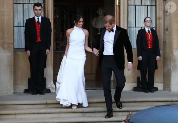 Le prince Harry, duc de Sussex, et Meghan Markle, duchesse de Sussex, quittent le château de Windsor à bord d'une Jaguar Type E cabriolet en tenue de soirée après leur cérémonie de mariage, pour se rendre à la réception à "Frogmore House" à Windsor le 19 mai 2018.