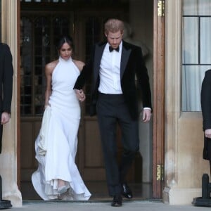 Le prince Harry, duc de Sussex, et Meghan Markle, duchesse de Sussex, quittent le château de Windsor à bord d'une Jaguar Type E cabriolet en tenue de soirée après leur cérémonie de mariage, pour se rendre à la réception à "Frogmore House" à Windsor le 19 mai 2018.