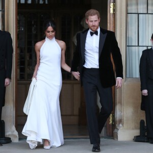 Le prince Harry, duc de Sussex, et Meghan Markle, duchesse de Sussex, quittent le château de Windsor à bord d'une Jaguar Type E cabriolet en tenue de soirée après leur cérémonie de mariage, pour se rendre à la réception à "Frogmore House" à Windsor le 19 mai 2018.