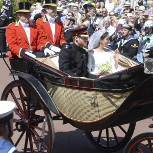 Le prince Harry, duc de Sussex, et Meghan Markle, duchesse de Sussex, lors de la procession en landau le jour de leur mariage le 19 mai 2018 à Windsor