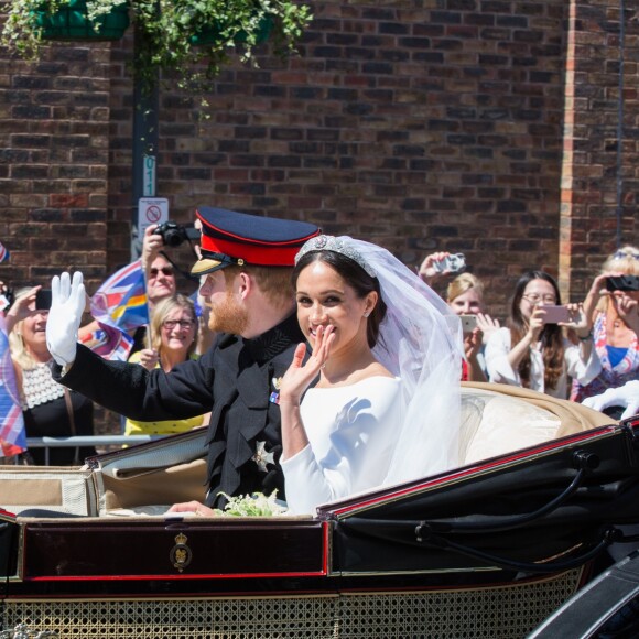 Le prince Harry, duc de Sussex, et Meghan Markle, duchesse de Sussex, lors de la procession en landau le jour de leur mariage le 19 mai 2018 à Windsor