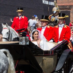 Le prince Harry, duc de Sussex, et Meghan Markle, duchesse de Sussex, lors de la procession en landau le jour de leur mariage le 19 mai 2018 à Windsor