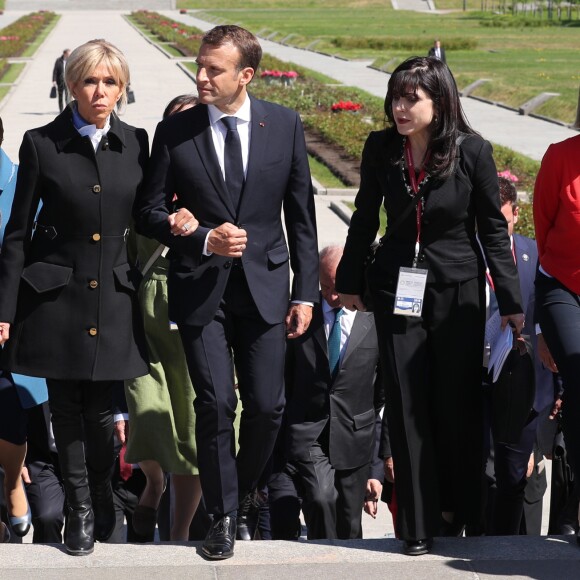 Le président de la République française Emmanuel Macron, sa femme la première dame Brigitte Macron et la ministre de la Culture Françoise Nyssen assistent à une cérémonie pour déposer des fleurs au monument de Mortherland au cimetière mémorial de Piskarevskoïe de Saint-Pétersbourg, Russie, le 25 mai 2018.