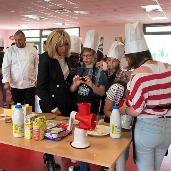 Brigitte Macron en visite au collège Camille du Gast (Achères, Yvelines) pour le concours Les Brigades Culinaires. La première dame n'était pas seule puisque le chef de l'Elysée, Guillaume Gomez, était aussi présent (à gauche de la photo).