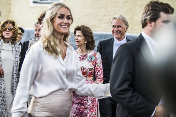 La reine Silvia de Suède et Fredrik Gottlieb (au centre, en arrière-plan) au mariage de Louise Gottlieb et Gustav Thott à Hölö au sud de Stockholm le 2 juin 2018.