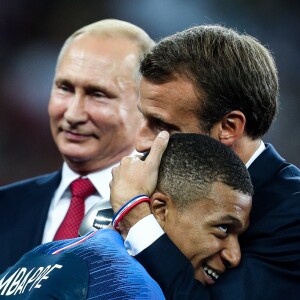 Vladimir Poutine pendant qu'Emmanuel Macron embrassé Kylian Mbappé après la victoire de la France face à la Croatie (4-2) en finale de la Coupe du Monde 2018 (FIFA World Cup Russia2018), le 15 juillet 2018.