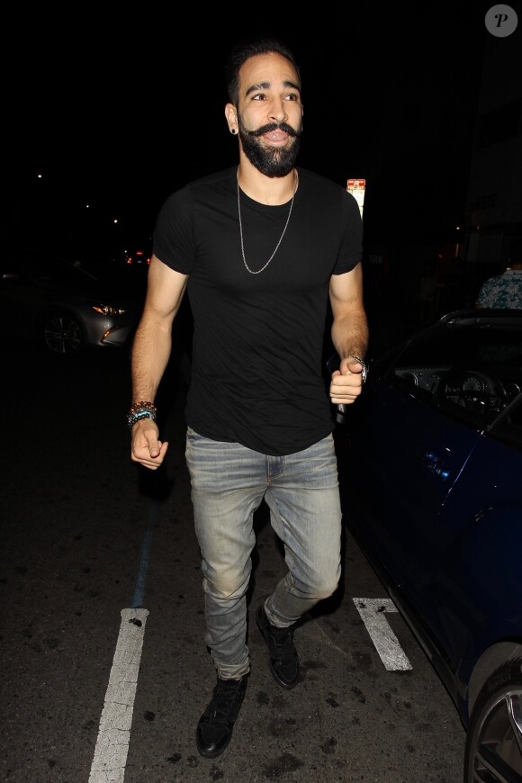 Exclusif - Adil Rami, défenseur de l'équipe de France et compagnon de Pamela Anderson arrive au club Warwick à Los Angeles pour célébrer la victoire des bleus, une réplique du trophée de la coupe du monde en main. Le 18 juillet 2018.