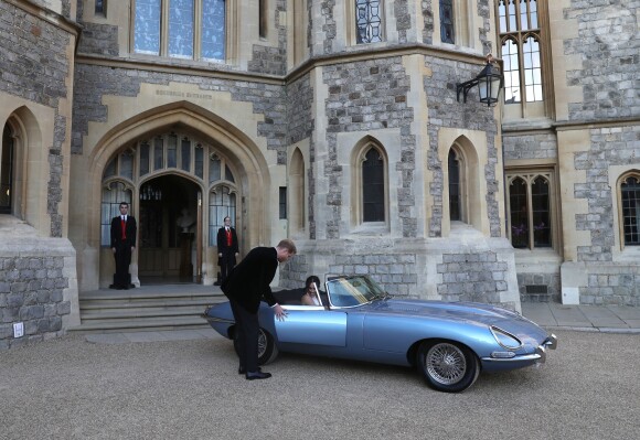 Le prince Harry, duc de Sussex, et Meghan Markle, duchesse de Sussex quittent le château de Windsor à bord d'une Jaguar Type E cabriolet en tenue de soirée après leur cérémonie de mariage, pour se rendre à la réception à "Frogmore House" à Windsor le 19 mai 2018.