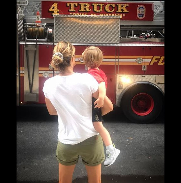 Amélie Mauresmo avec son fils Aaron devant un camion de pompiers à New York le 22 août 2018.