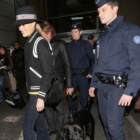 Johnny avec son chien Santos, Laeticia Hallyday - Johnny Hallyday est arrive ce matin a Paris en provenance de Los Angeles avec sa femme Laeticia, ses filles Jade et Joy, Elyette (la grand-mere de laeticia), son chien Santos, la nounou, ses musiciens dont son guitariste Robin Le Mesurier et ses choristes le 8 decembre 2013.