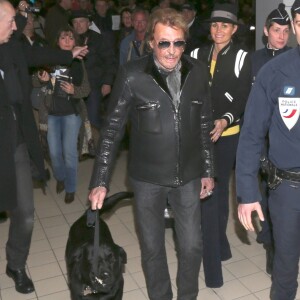 Johnny avec son chien Santos, Laeticia Hallyday - Johnny Hallyday est arrive ce matin a Paris en provenance de Los Angeles avec sa femme Laeticia, ses filles Jade et Joy, Elyette (la grand-mere de laeticia), son chien Santos, la nounou, ses musiciens dont son guitariste Robin Le Mesurier et ses choristes le 8 decembre 2013.