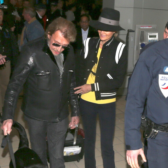 Johnny avec son chien Santos, Laeticia Hallyday - Johnny Hallyday est arrive ce matin a Paris en provenance de Los Angeles avec sa femme Laeticia, ses filles Jade et Joy, Elyette (la grand-mere de laeticia), son chien Santos, la nounou, ses musiciens dont son guitariste Robin Le Mesurier et ses choristes le 8 decembre 2013.