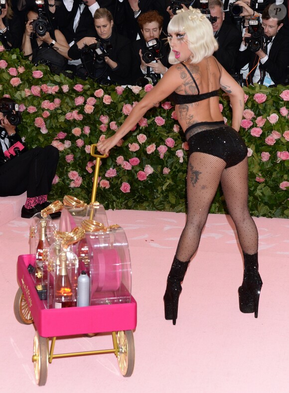 Lady Gaga fait un striptease lors de son arrivée à la 71e édition du MET Gala sur le thème "Camp: Notes on Fashion" au Costume Intitute du Metropolitan Museum of Art à New York, le 6 mai 2019.